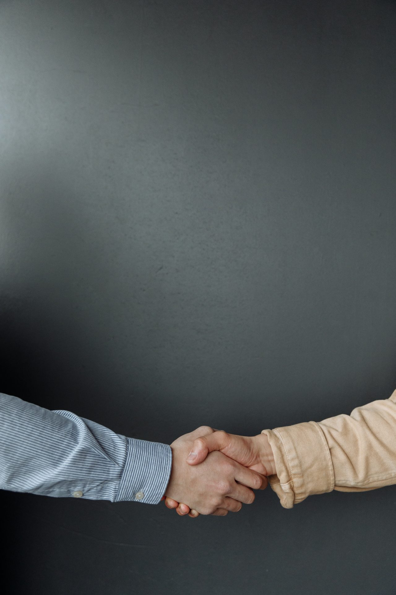 handshake between two people with a black back drop and CRM software written at the top center
