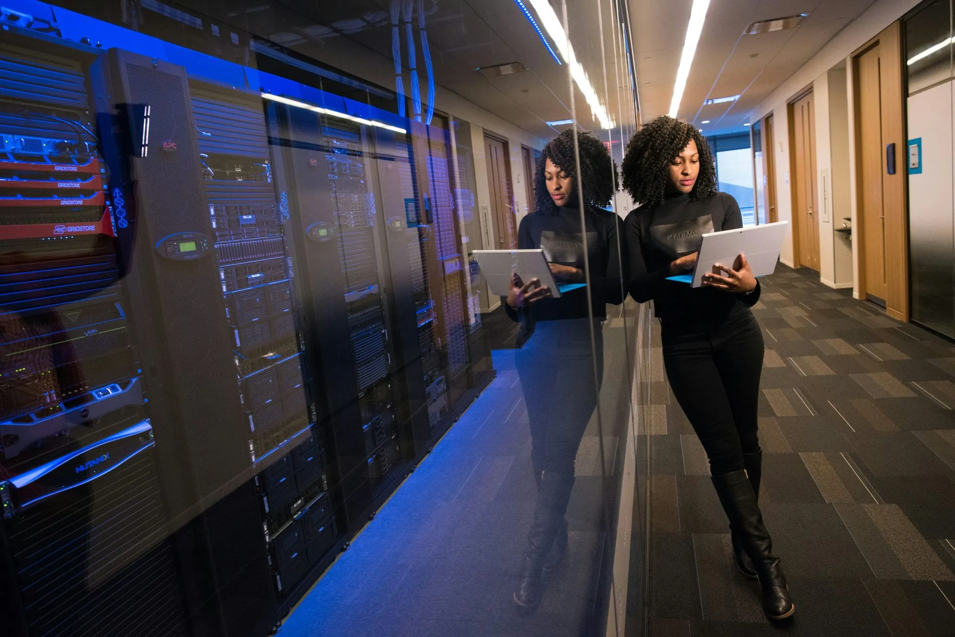 Developer leaning against sealed web host server stacks
