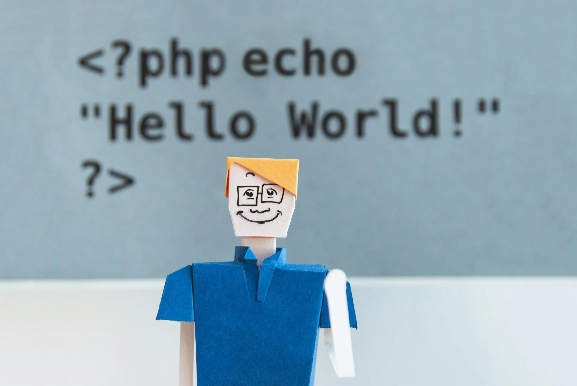 Paper cut-out man waving with PHP Hello world above